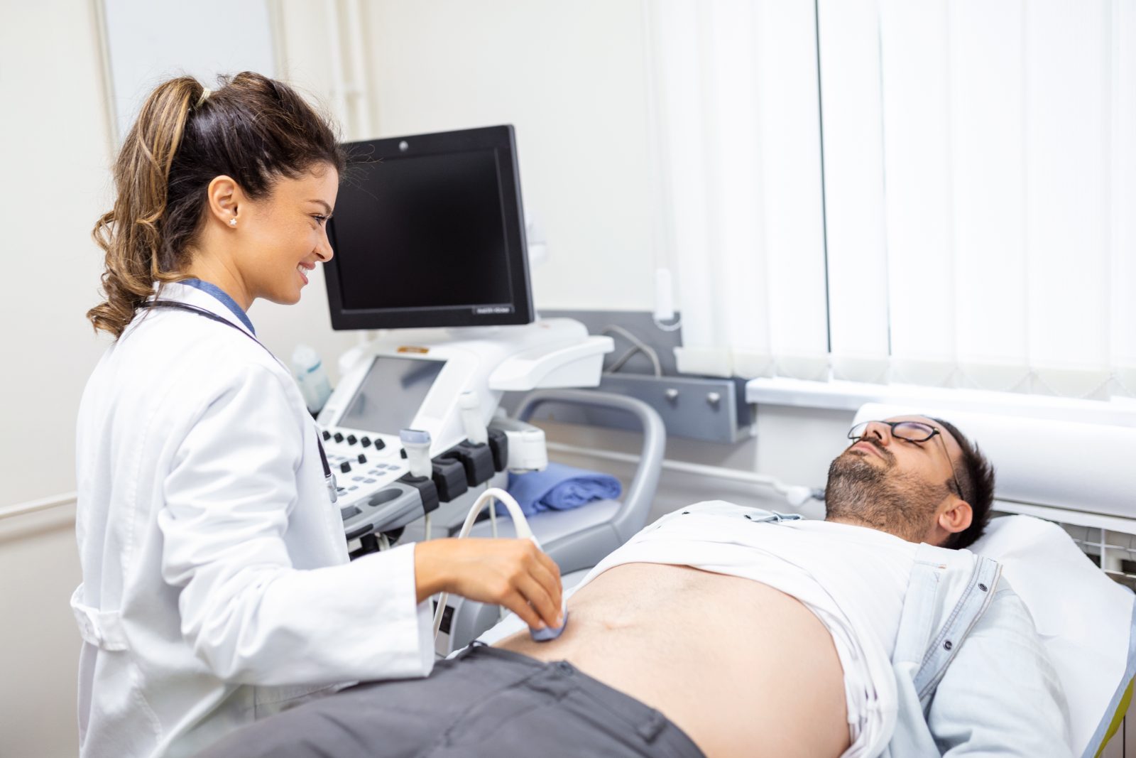 Médica faz ultrassom em paciente na maca